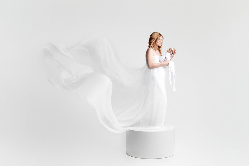 st-louis-newborn-photographer-mom-in-flowing-white-fabric-standing-on-pedestal