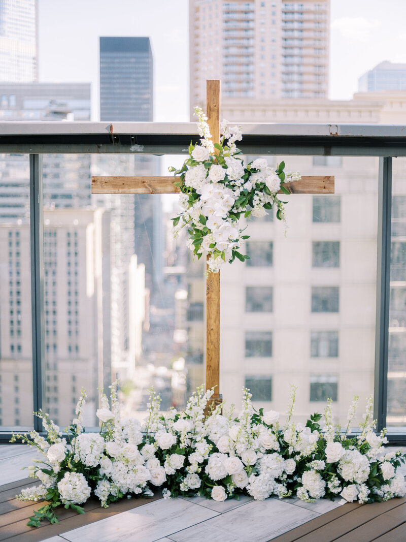 Bride in white suite with colorful flowers in hair.
