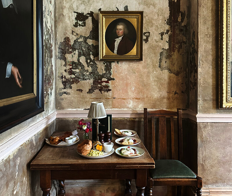 Photo tour historic home designer British pub in London Wilton Arms features aged walls, formal portraits, and antique art that highlight historic British design.