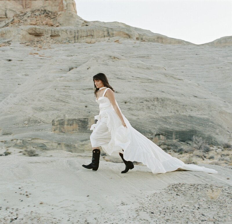 Editorial bridal portraits running through Arizona desert in wedding dress and boots | Artful portraits by Arizona luxury wedding photographer Tess Gearhart