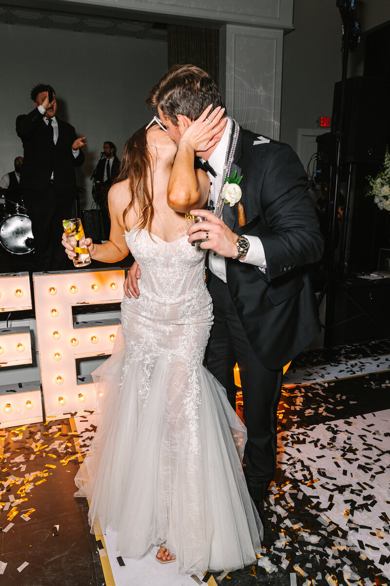 Flash photo of bride and groom kissing on dance floor