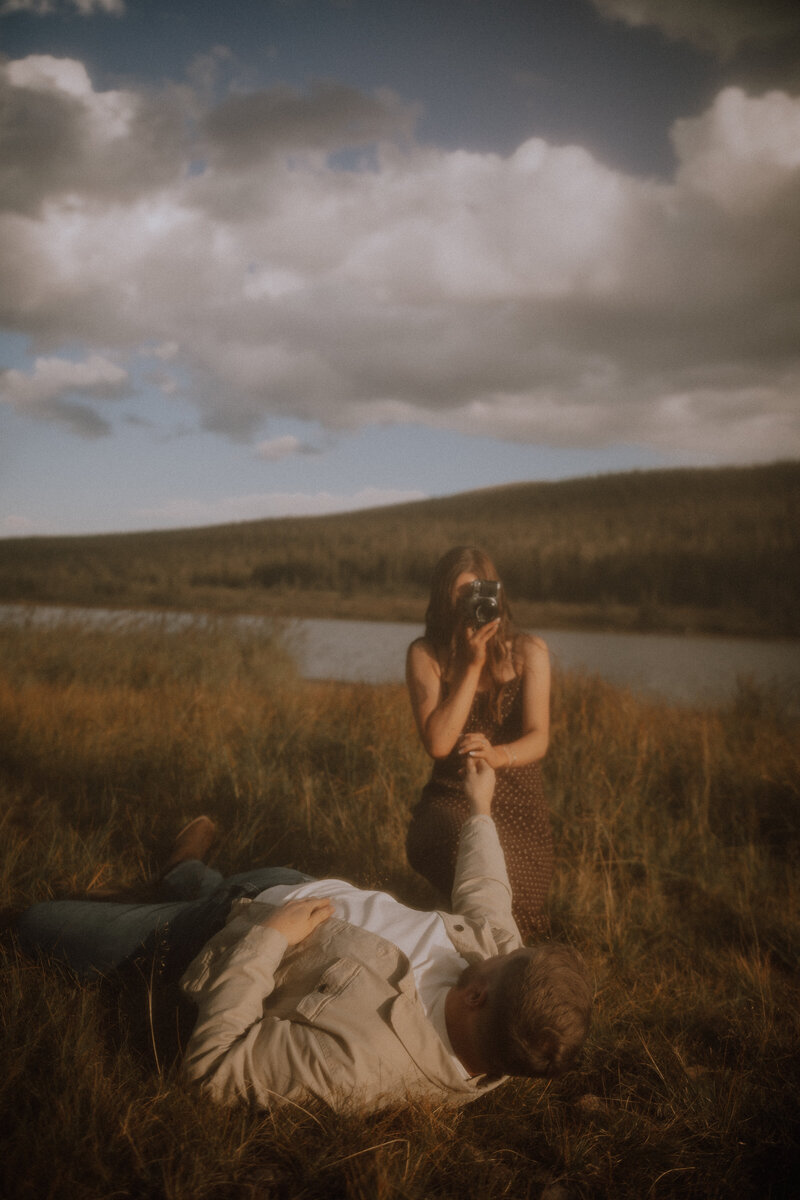 girlfriend grabs boyfriends hand with her vintage film camera