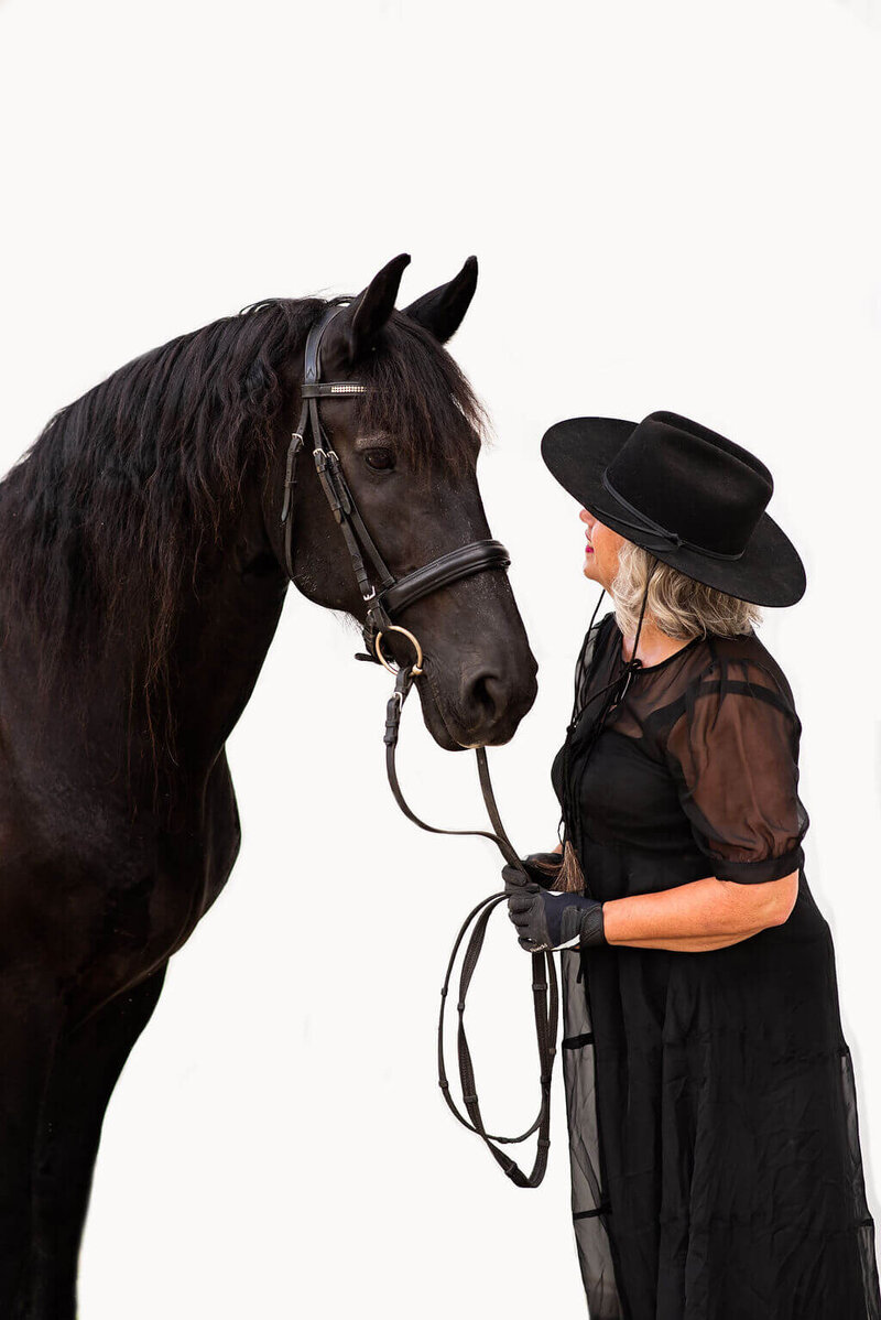 Postmenopausal woman with gray pro-aging wellness coach with Friesian horse
