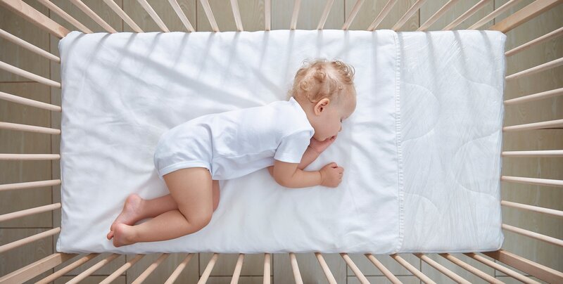 Baby sleeping in crib after two week sleep consultation