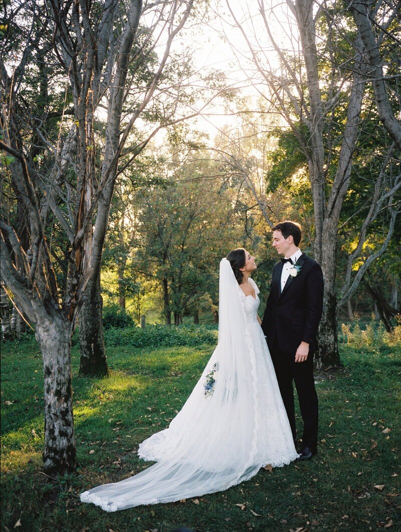 minnesota wedding photo of bride and groom outside at sunset in grassy field by trees taken by tom thornton photography