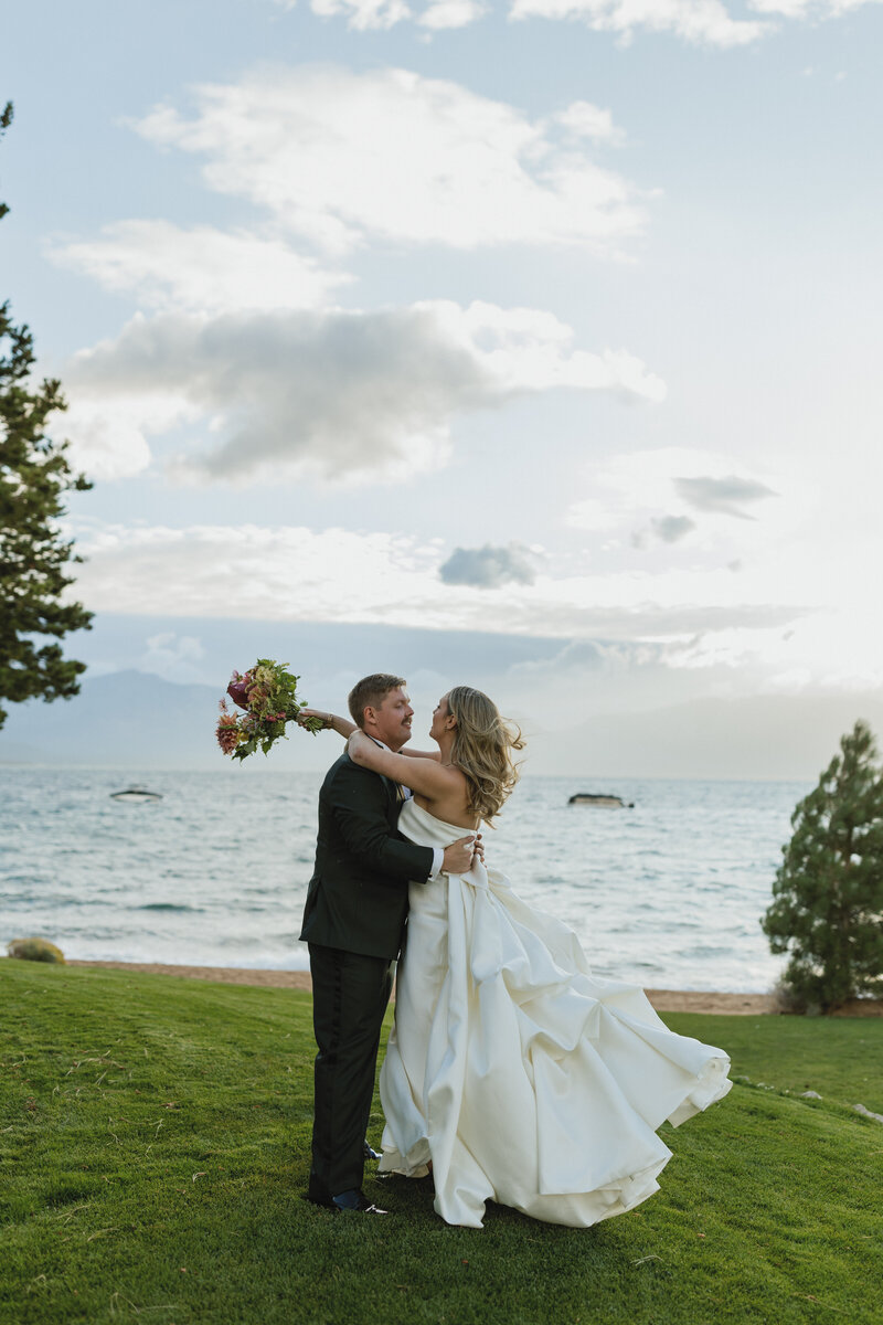 bride smelling her bridal bouquet with lake in the background
