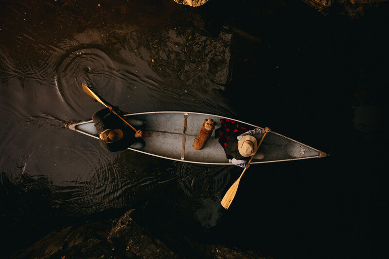 couple in a canoe with a dog