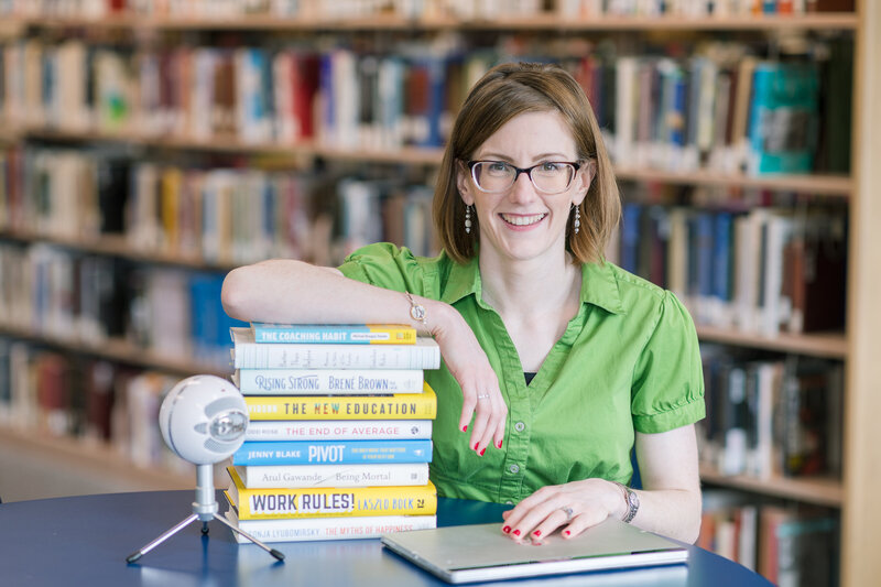 woman with stack of books in library