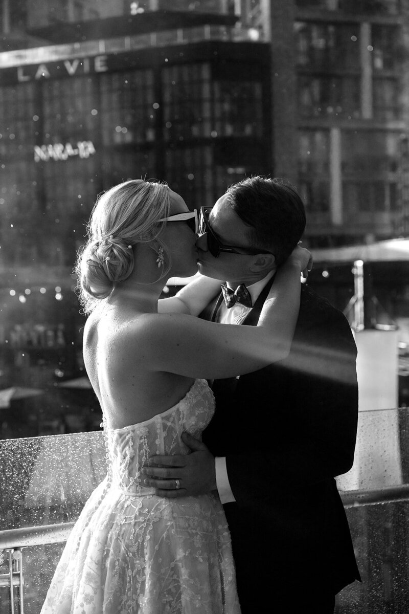 Bride and groom kiss in the rain at the Wharf in DC
