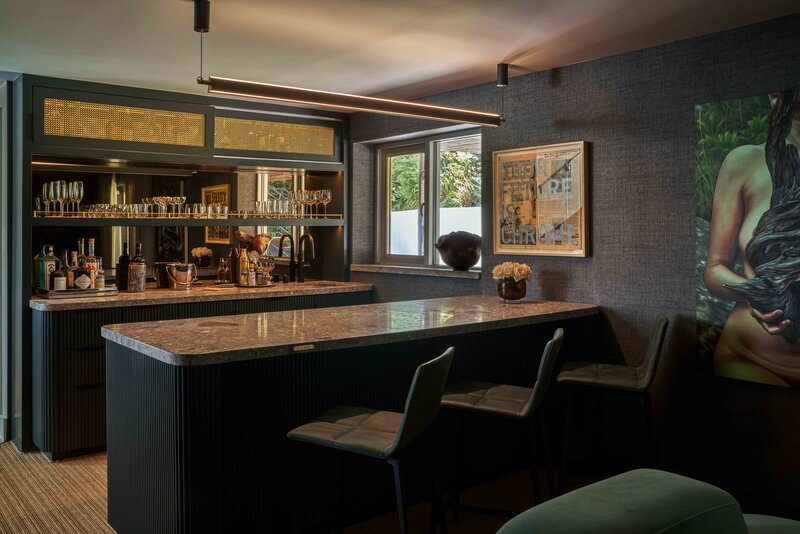 dark moody basement wet bar interior design Los Angeles custom built ins bespoke mood lighting fine art liquor bar display mirrored backsplash minimal ambient design ideas plans mini bar