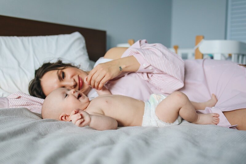 mom and baby playing in bed