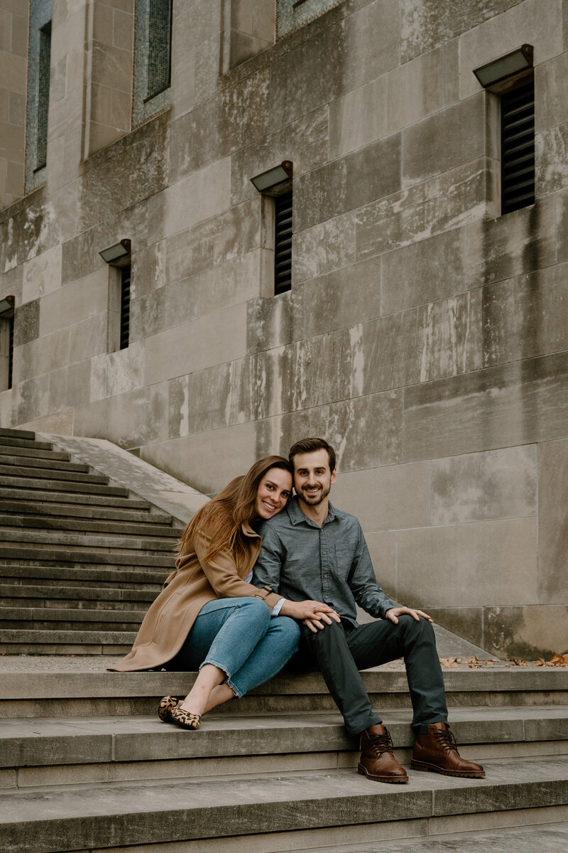 Engagement photos with bride and groom sitting on steps at Kansas City WWI memorial.