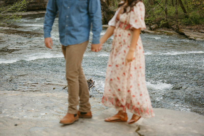 Blurred image of couple walking hand in hand by the water during Tennessee engagement session