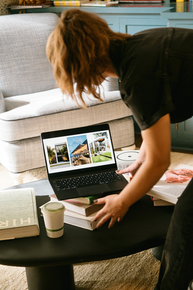 Image of founder Noel styling a coffee table with books, coffee and a laptop