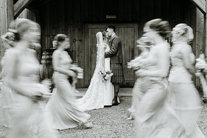 bride and groom laughing as thy walk towards camera with loch and hills in background natural alternative wedding photographer scotland