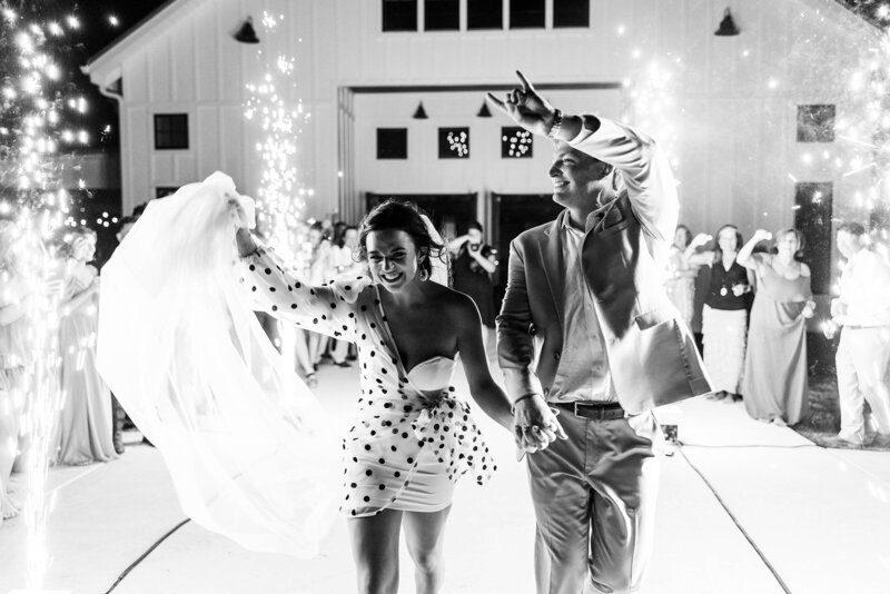 Black and white photo of bride and groom during cold sparks reception exit