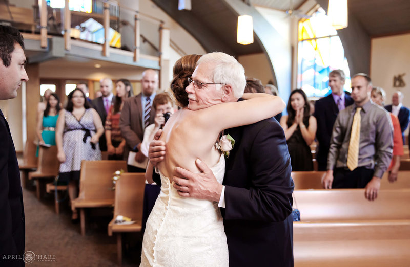 Bride hugs her dad at Saint Mary's Catholic Church in Breckenridge Colorado