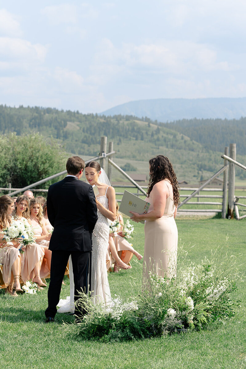 Diamond Cross Ranch Wedding for Maggie + Kinsly by Foxtails Photography. Couple reads vows to each other during the ceremony on the lawn at Diamond Cross Ranch 