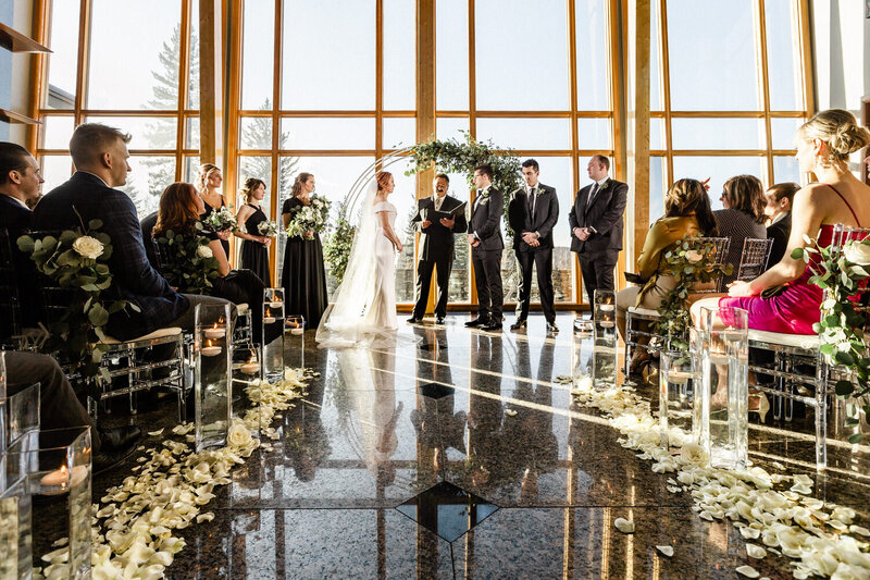 This moving photo shows the bride and groom gazing into each other's eyes as they exchange vows during their wedding ceremony at Azuridge Estate Hotel. Surrounded by the elegant venue's grounds, the couple's deep connection and the solemnity of the moment are beautifully captured.