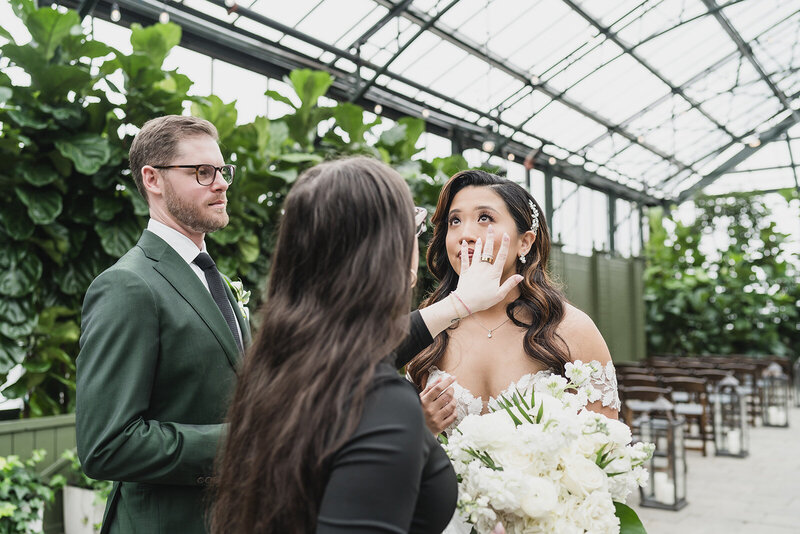 Candid moment of Karli Dawson gently affirming a tearful bride at Planterra Conservatory, capturing the emotional weight of the day with calm presence and intuitive support as a second shooter and memory-keeper