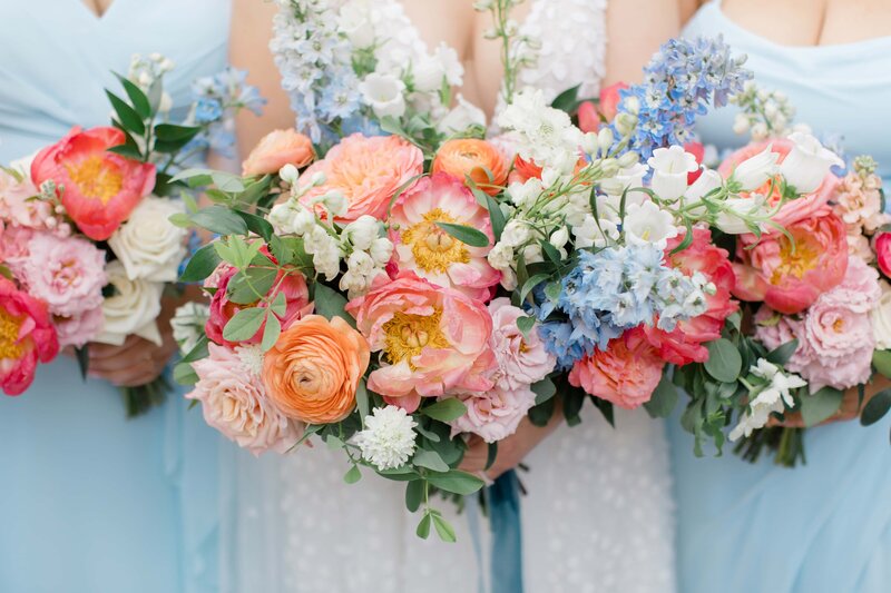 A bride and her bridemaids holding their floral bouquets