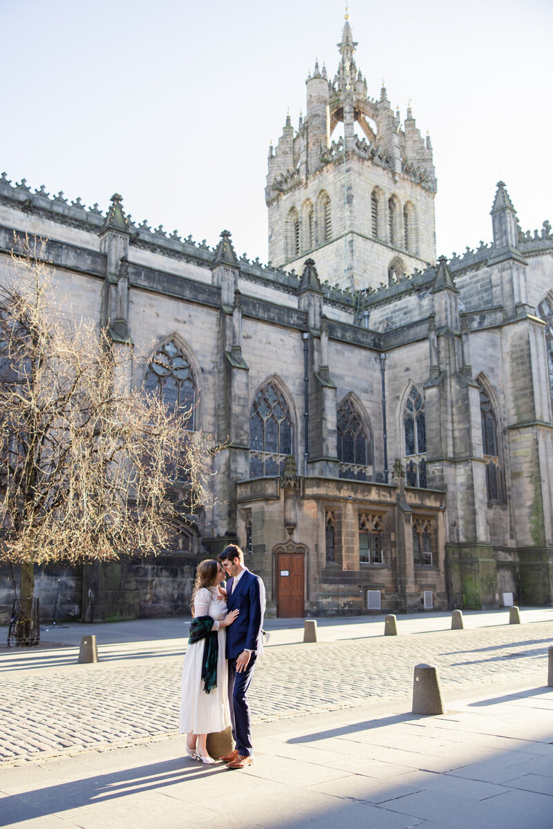 brie and groom hug in front of cathedral