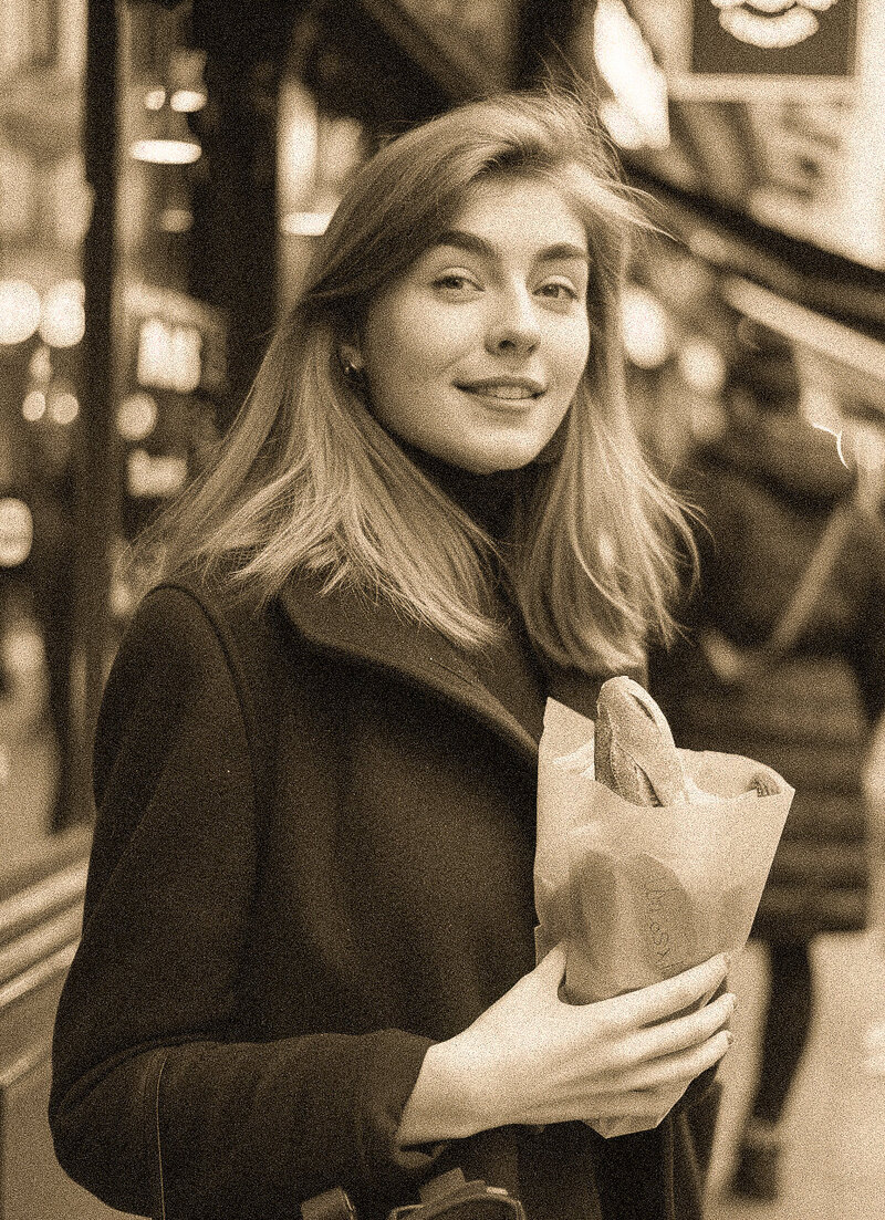 LUCCA lifestyle branding with vintage-style photo of woman holding bread on city street, evoking timeless European charm.