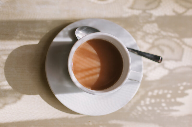 Cup of tea in dappled light caused by net curtains 