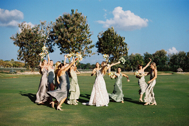 Bride and bridesmaids celebrating on the lush fairway of Teeth of the Dog Golf Course at Casa de Campo — destination wedding captured on film by Asia Pimentel Photography.