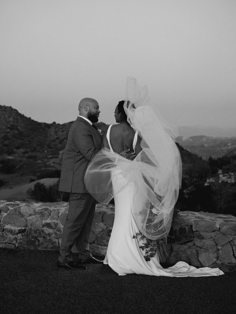 a black and white image of a bride and her father embracing one another