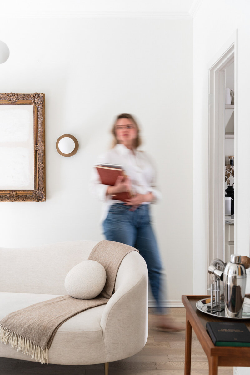 Motion blurred image of a woman walking holding a laptop and notebooks