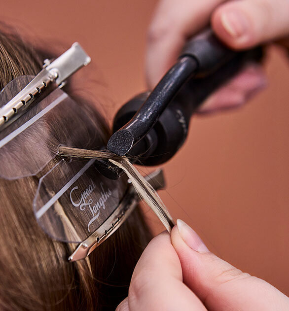 Application of Great Lengths hair extensions using precision tools and clips for seamless blending.