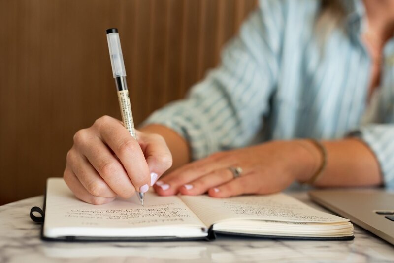 Tara Dunn writing coaching notes in a notebook