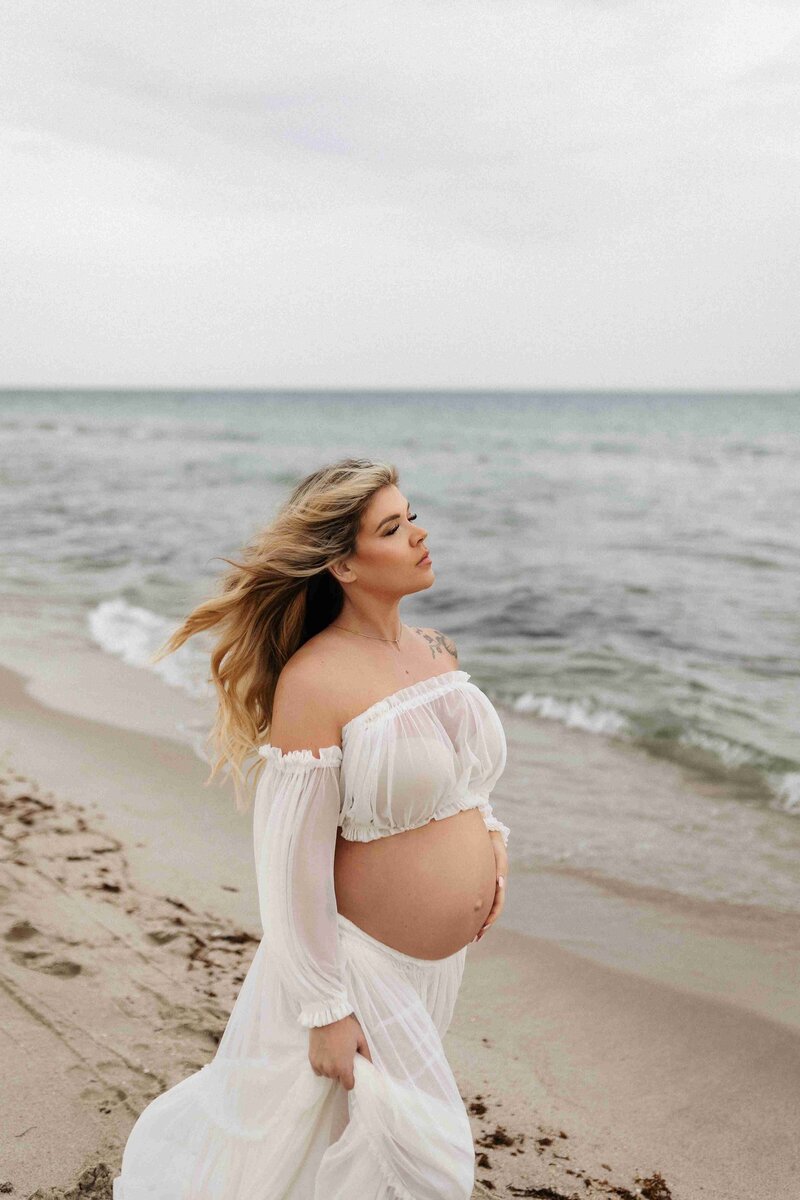 Photographer captures serene maternity portrait of a pregnant woman on the beach