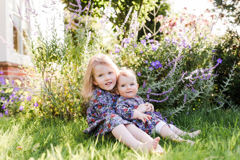 two little sisters hugging in english garden