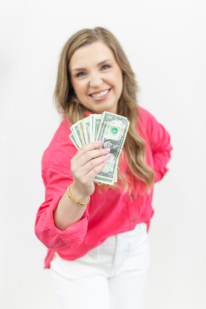 Erika smiling, holding a stack of bills