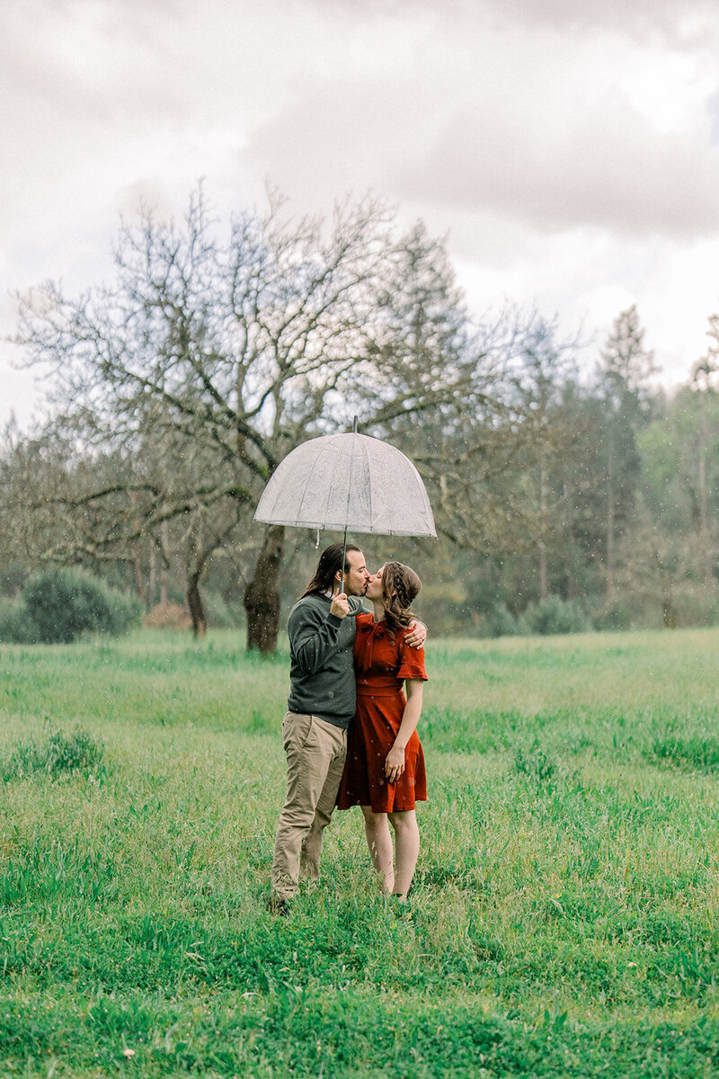 A couple wrapped in a cozy blanket during their engagement session at the picturesque Filoli Gardens in Woodside, California, captured by Tiffany Longeway Photography.