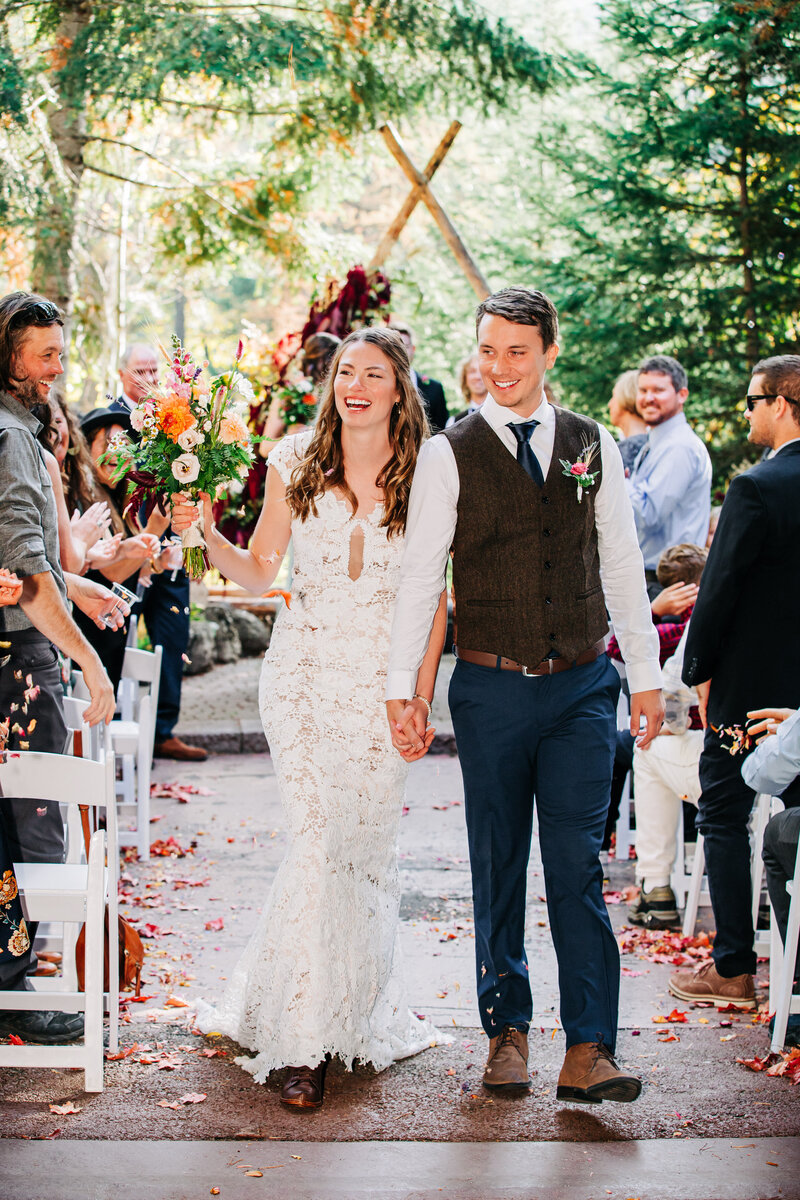 Bride and groom exiting after ceremony at Izaak Walton Inn in Essex, MT