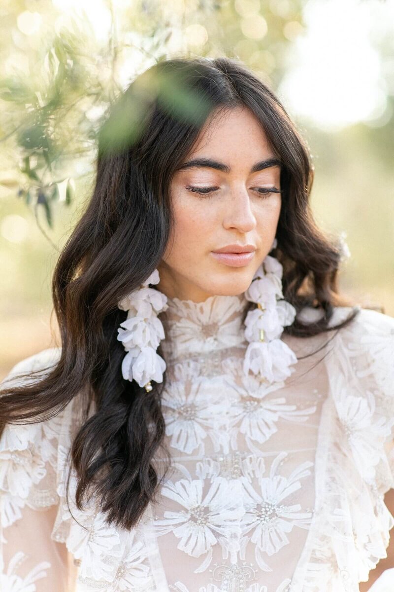 Woman wearing a white top and floral earrings