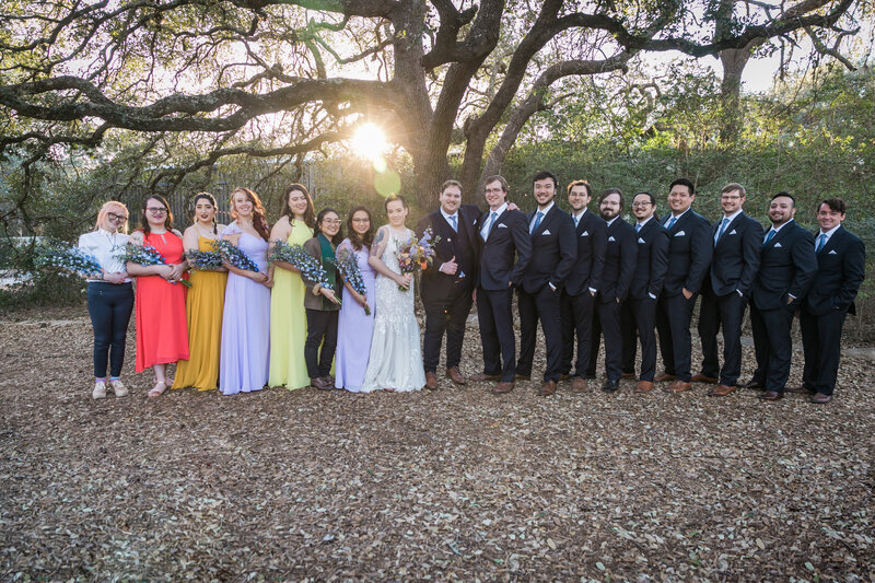 wedding party poses with sunset