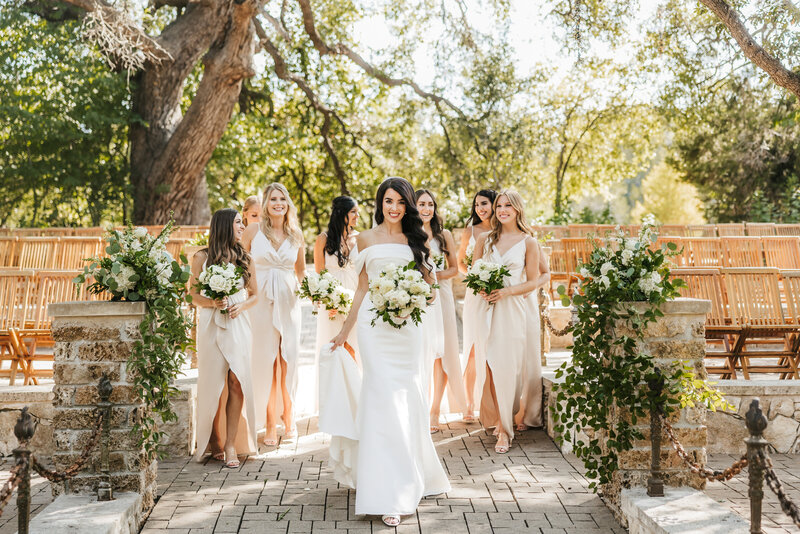 bride walks with a smile with her bridesmaids