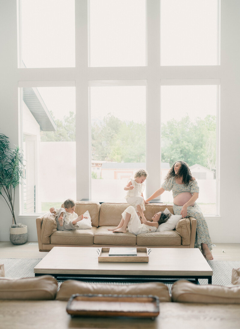 Peaceful in-home maternity moment photographed by a Riverton newborn photographer, highlighting a glowing mother-to-be and her young children in a beautifully lit space.