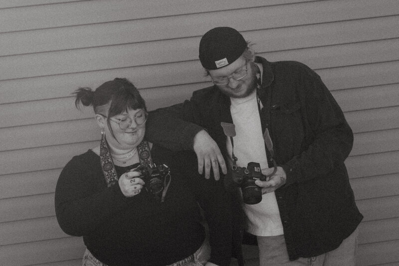 A husband picks up his wife and spins around in a summer field, laughing and embracing their love