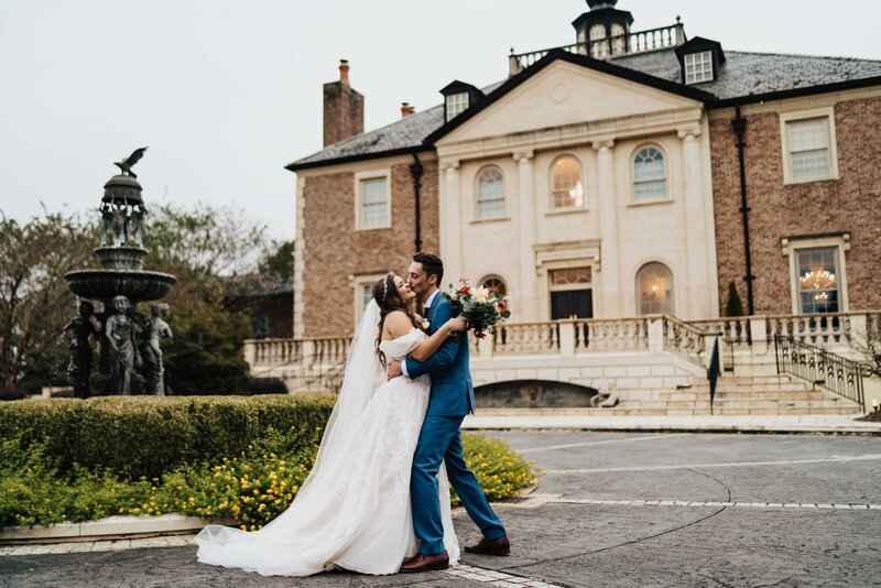 bride and groom kiss in front of European building