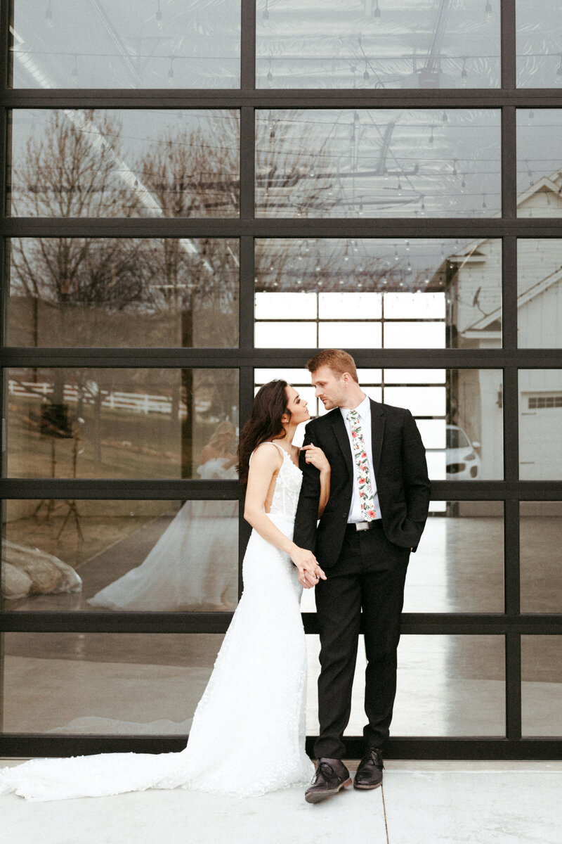 Couple standing in front of those gorgeous glass barn doors.