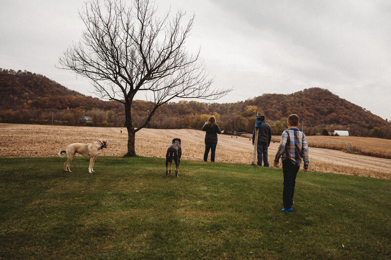 faceless family staring at child running into field