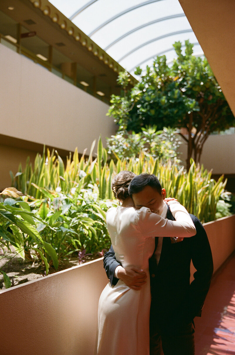 Bride and groom sharing moment in rotunda garden at Marin Civic Center.