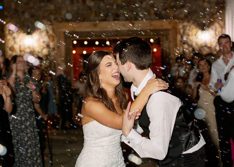 Couple smiling at their wedding with bubble exit