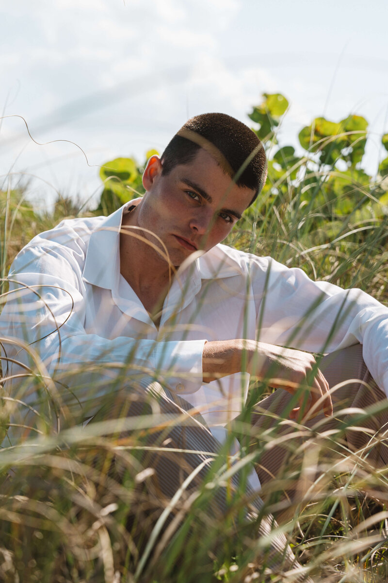man modeling and sitting in field
