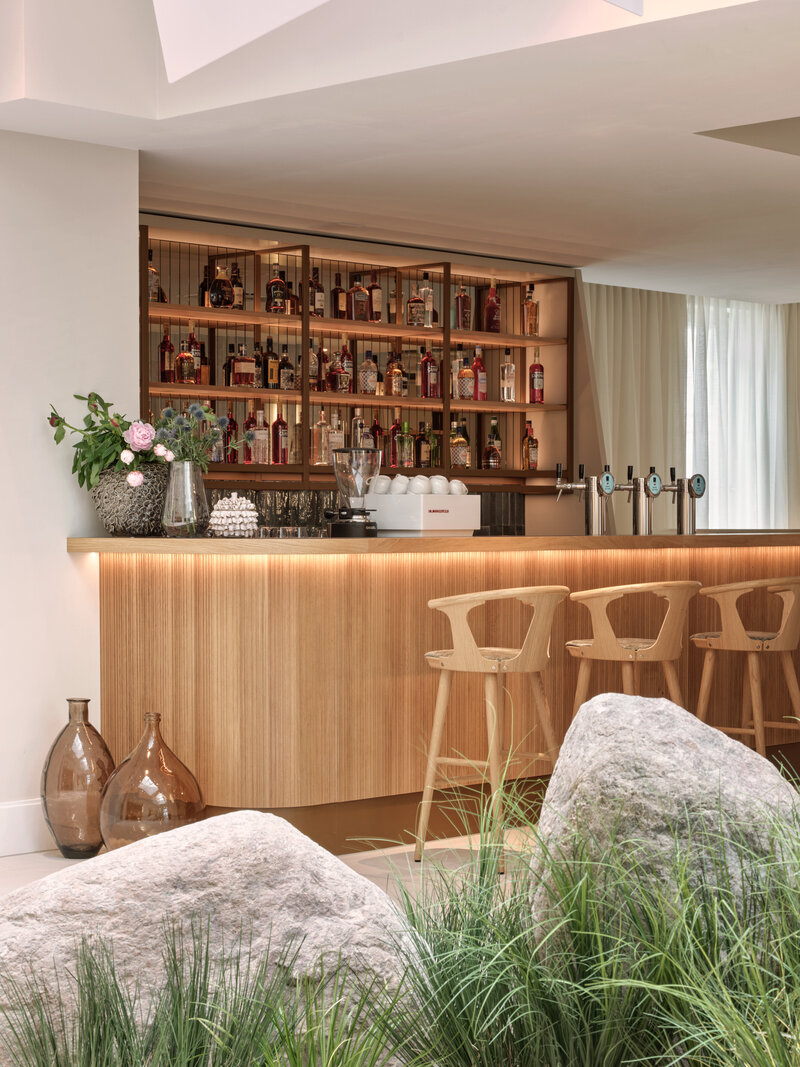 Holzverkleidete und ausgeleuchtete Bar im Hotel the breeze.